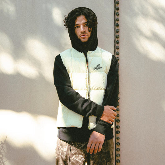 MODEL IN 100 Thieves x Malbon Flintlock Puffer Vest - Sand